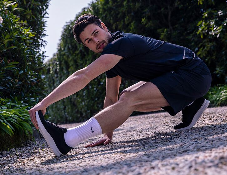 Man stretching out wearing sports gear and cotton sports socks