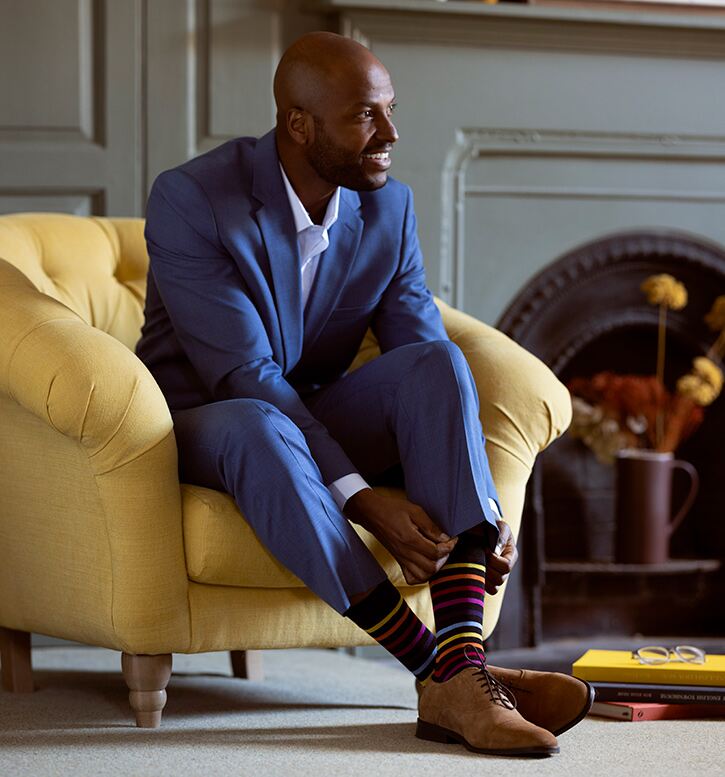 Man in blue suit with multicoloured stripe socks