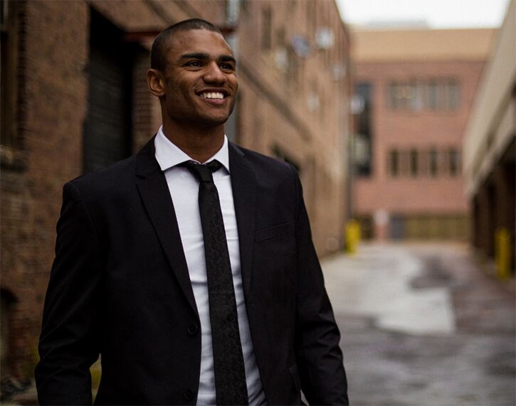 What colour tie should you wear for an interview? Man in black suit, white shirt and black tie