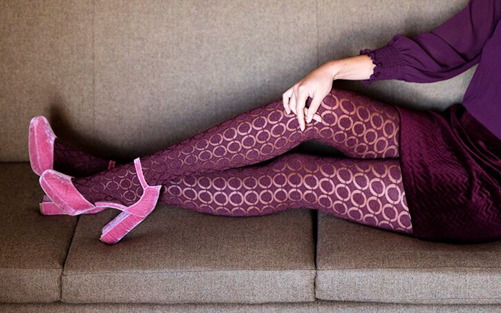 Woman on couch wearing pink patterned and sheer tights